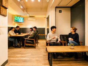 a group of people sitting at tables in a room at Akasaka Guesthouse HIVE in Tokyo