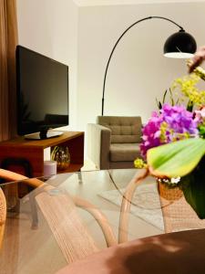 a living room with a table and chairs with flowers at Boutique Home Bad Iburg in Bad Iburg
