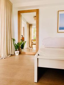 a bedroom with a white bed and a mirror at Boutique Home Bad Iburg in Bad Iburg