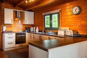 a kitchen with a counter and a clock on the wall at Oakbank Farm in Lamlash