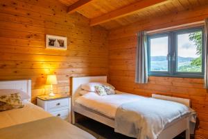 a bedroom with two beds in a log cabin at Oakbank Farm in Lamlash
