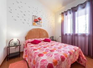 a bedroom with a bed with a pink comforter and a window at Villa Fior di mare in Monte Nai