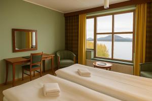 a hotel room with two beds and a desk and a window at Saxnäsgården Hotell in Saxnäs +17 photos