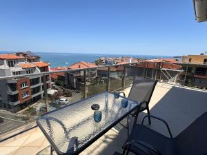 a table on a balcony with a view of the ocean at Hotel Filland in Sozopol