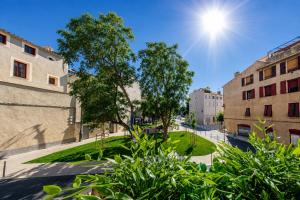 a street in a city with buildings and trees at RétroMirabeau - CHAMBRE Suite & APPARTEMENTS de Charme - Localisation Prémium in Narbonne