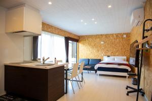 a kitchen and a bedroom with a bed in a room at Win Village in Sasebo