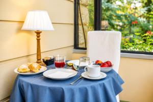 a table with a blue table cloth with breakfast food on it at Villa Romantica Wellness & SPA in Lucca