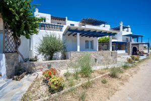 a white villa with a garden in front of it at Niel Serifos in Serifos Chora