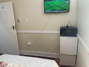 a room with a tv on a wall with a televisionurrection at Zanem Guest House in Potchefstroom +25 photos