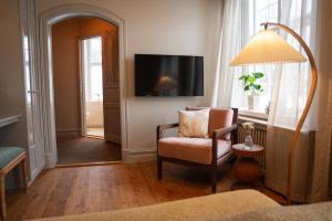 a living room with a chair and a television at Krusenberg Herrgård in Krusenberg