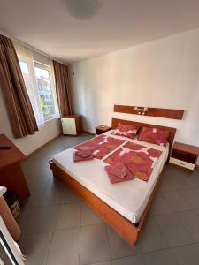 a bedroom with a large bed with red pillows at Hotel Filland in Sozopol +6 photos