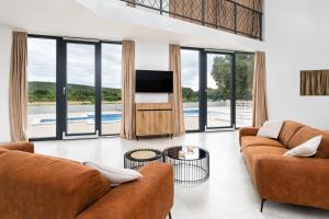 a living room with two couches and a tv at Villa Bagulina in Drniš