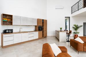 a kitchen with white cabinets and a living room at Villa Bagulina in Drniš