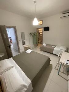 a hotel room with two beds and a television at B&B La Via di Casa in San Leone