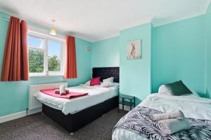 two beds in a room with blue walls at 4 Bedroom Central Birmingham in Birmingham