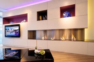 a living room with a fireplace and a tv at Appart Hôtel Clément Ader in Toulouse