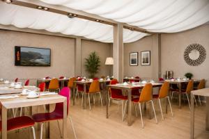 a dining room with tables and chairs and a white canopy at Appart Hôtel Clément Ader in Toulouse
