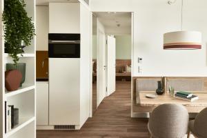 a kitchen and dining room with a table and chairs at Falkensteiner Residences Jesolo in Lido di Jesolo