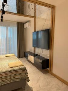 a bedroom with a flat screen tv on the wall at Azur Properties 72 in Shkorpilovtsi +14 photos