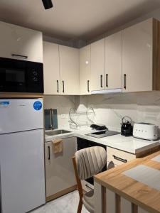 a kitchen with white cabinets and a white refrigerator at Azur Properties 72 in Shkorpilovtsi