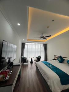 a bedroom with a bed and a desk and a ceiling at Bảo Nhi Paradise Hotel in Làng Môn