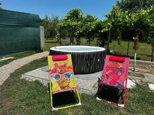 two chairs sitting in the grass next to a trampoline at Casale Rûsignul in Cassegliano