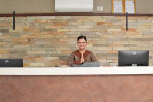 a woman sitting at a counter in a office at ila Comfort Baglung in Bāglung