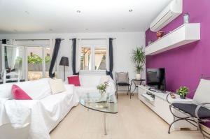 a living room with a white couch and purple walls at Xalet S'Escaleta in Cala Santanyi
