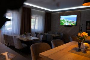 a restaurant with tables and chairs and a television on the wall at Penzion u Bednářů in Pavlov