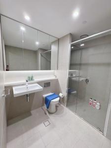 a bathroom with a toilet and a sink and a shower at Floor-to-Ceiling Park View Oasis at Olympic Park Free Parking Sleeps 5 in Sydney +19 photos
