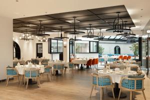 a dining room with white tables and chairs at Grand Bloom Hotel in Baghdād