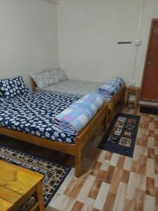 a row of beds in a room with wooden floors at Za Homestay in Cherrapunji