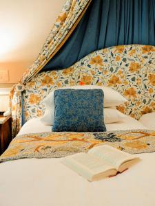 a bed with a pillow and an open book at Hotel La Neige in Hakuba