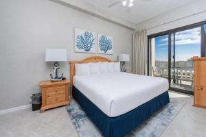a bedroom with a bed and a large window at Phoenix VI 6004 in Orange Beach