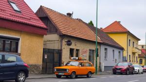 an orange car parked on the side of a street at Confort Flat in Braşov