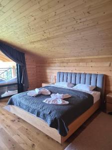 a bedroom with a large bed with a wooden wall at Гірська Лаванда in Skhidnitsa
