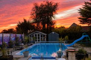 Ein Swimmingpool mit Sonnenuntergang im Hintergrund in der Unterkunft SherPai Lodge in Kent