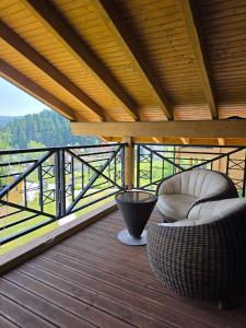 a balcony with two chairs and a view of the water at Гірська Лаванда in Skhidnitsa