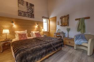 a bedroom with a large bed and a chair at Chez Philippe - Appartements et Chalets - Panoramic Village vue Glaciers in La Grave