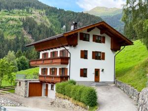 a house on a hill with mountains in the background at Ferienhaus Riedberg in Ried im Zillertal