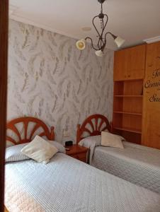 a bedroom with two beds and a wall at Casa Chus in Foz