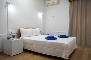 a bedroom with a bed with two blue towels on it at Le Village Hotel in Limassol