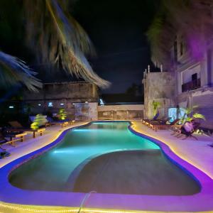a swimming pool at night with purple lights at Ridho Malik Hotel in Bumbang