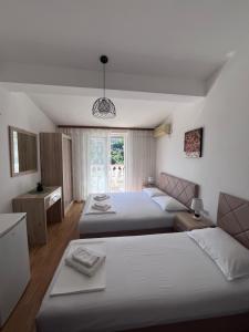 a hotel room with two beds and a window at Castello Apartments in Ulcinj