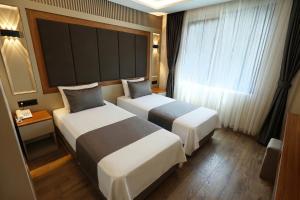 a hotel room with two beds and a window at Kalkan Hotel in Istanbul