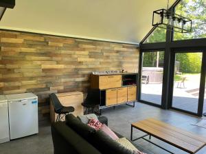 a living room with a couch and a wooden wall at Ziemupes namiņš in Ziemupe