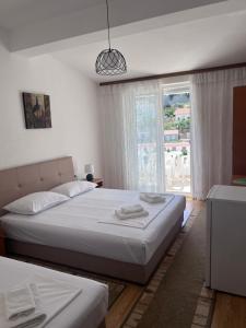 a bedroom with two beds and a large window at Castello Apartments in Ulcinj +15 photos