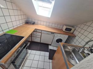 a small kitchen with a sink and a washing machine at Vous êtes bienvenue in Ramstein-Miesenbach
