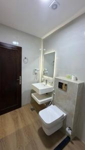 a bathroom with a toilet and a sink and a mirror at Selena Hotel Aqaba in Aqaba