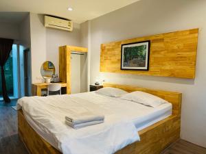 a bedroom with a large bed with two towels on it at บ้านไร่ดอกแก้ว in Chom Bung +61 photos